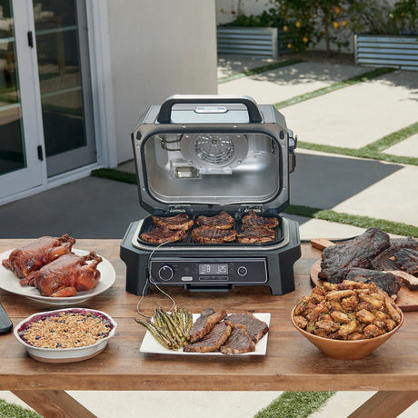 Ninja OG853A XL outdoor grill on a table with the lid open