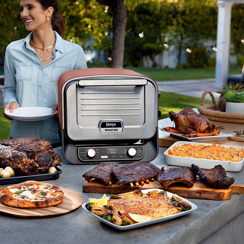 Ninja OO101 Terracotta Red oven with a variety of cooked food