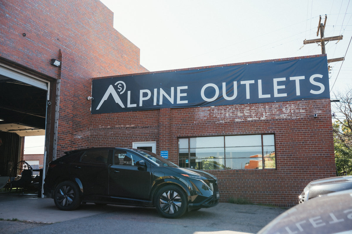 Alpine Outlets storefront at 5065 Colorado Blvd in Denver: a red brick building with a large Alpine Outlets sign